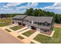 Aerial view of townhouses with driveways, landscaping, and street at 5332 Cherrie Kate Ct # 1703, Stanley, NC 28164