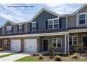 Townhouses with stone and gray siding, two-car garages, and landscaping at 5332 Cherrie Kate Ct # 1703, Stanley, NC 28164