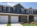 Townhouses with stone and gray siding, two-car garages, and landscaping at 5332 Cherrie Kate Ct # 1703, Stanley, NC 28164