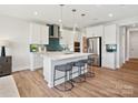 Modern kitchen with white cabinets, island, and teal hexagon backsplash at 97 Seven Oaks Lndg, Belmont, NC 28012