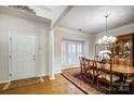 Formal dining room featuring a wood table, chandelier, and plantation shutters at 5300 Berkeley Pines Ln, Charlotte, NC 28277