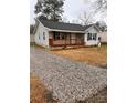 Newly built home with gray siding, gravel driveway, and wooden porch at 203 Peyton St, Chester, SC 29706