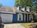 Blue house exterior, featuring a white garage door and landscaping at 5720 Ebley Ln, Charlotte, NC 28227