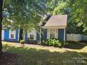 Side view of a blue house nestled amongst lush greenery at 5720 Ebley Ln, Charlotte, NC 28227