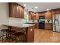 Updated kitchen with an island, granite countertops, and dark wood cabinets at 1447 London Dr, Rock Hill, SC 29732