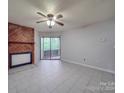 Living room with tile floors, fireplace, and sliding glass doors to patio at 4616 Sharon Chase Dr # B, Charlotte, NC 28215