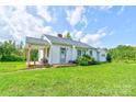 White ranch house with front porch, surrounded by a spacious lawn at 1414 S Post Rd, Shelby, NC 28152