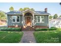 Charming green house with a covered porch and brick steps at 217 Rhodes St, Lincolnton, NC 28092