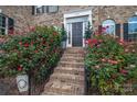 Brick staircase with black railing flanked by lush red rose bushes at 4050 Halyard Dr, Denver, NC 28037