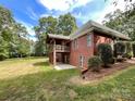 Back of house showing patio and deck with wooded views at 2510 Doster Rd, Monroe, NC 28112