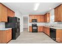 Kitchen with wood cabinets and black appliances at 8708 Berrybrook Ln, Charlotte, NC 28269