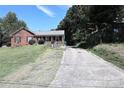 Brick ranch home with a long driveway and mature trees at 2209 Laura Dr, Charlotte, NC 28212