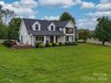 Two story home with white exterior, dark roof, and a large front porch at 540 Harbor Rd, Norwood, NC 28128