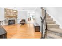 Living room with hardwood floors, stone fireplace, and view to kitchen at 10320 Berkeley Pond Dr, Charlotte, NC 28277