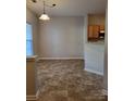 Simple dining area with light flooring and kitchen access at 7945 Mariners Pointe Cir, Denver, NC 28037