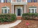 Welcoming front entry with a black door and landscaping at 1120 Red Porch Ln, Matthews, NC 28105