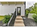 Modern front entrance with black door and metal railing at 8707 Nolley Ct, Charlotte, NC 28270