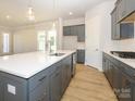 Modern kitchen with gray cabinets, quartz countertops and island at 1110 Lowland Way, Waxhaw, NC 28173