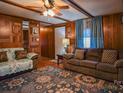 Living room with wood paneling, ceiling fan, and ample seating at 4537 Sunrise Beach Rd, Catawba, NC 28609