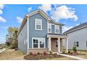 Two-story house with blue siding, brick accents, and landscaping at 502 Amhurst Sw St # 001, Concord, NC 28025