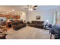 Open living room with brown reclining sofas and a view of the kitchen at 343 Ox Bow Cir, Mount Holly, NC 28120