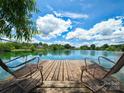 Relaxing lakefront view with wooden dock and chairs at 7204 E Nc 218 Hwy, Marshville, NC 28103