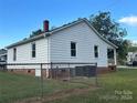 Side view of a white house with a chain link fence and grassy yard at 2407 Vale Ave, Kannapolis, NC 28081