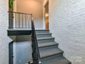 Interior stairs with carpeted steps and metal railings at 4913 Park Rd # F, Charlotte, NC 28209