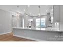 Modern kitchen with island and contemporary lighting at 1031 Seven Sisters Ave, Monroe, NC 28110