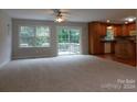 Spacious living room with carpeting, a sliding glass door, and kitchen access at 8885 Brandon Cir, Concord, NC 28025