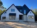 Modern farmhouse with white and black exterior, stone accents, and attached garage at 136 Castleview Ln, Mooresville, NC 28115