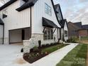 Stylish home with a side view showcasing a stone facade, attached garage, and manicured landscaping at 136 Castleview Ln, Mooresville, NC 28115