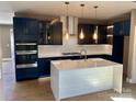 Stylish kitchen featuring navy blue cabinetry, quartz countertops, and a double oven at 1243 10Th Street Nw Pl, Hickory, NC 28601
