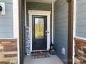 Inviting house entrance with a dark gray door, stone accents, and a welcome mat at 16835 Cozy Cove Rd, Charlotte, NC 28278