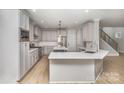 Modern kitchen with white cabinets, large island, and stainless steel appliances at 2305 Sanders Ave, Charlotte, NC 28216