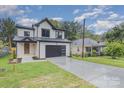 Modern farmhouse style home with a dark garage door and landscaping at 2305 Sanders Ave, Charlotte, NC 28216