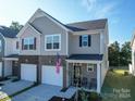 Two-story townhome with gray siding, two-car garage, and small front porch at 13111 Cottage Crest Ln, Charlotte, NC 28273