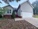 Ranch home with gray siding, attached garage, and landscaping at 5115 Rosemede Dr, Charlotte, NC 28227