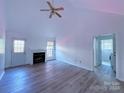 Living room with vaulted ceiling, fireplace, and vinyl flooring at 5115 Rosemede Dr, Charlotte, NC 28227