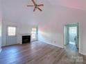 Living room with vaulted ceiling, fireplace, and vinyl flooring at 5115 Rosemede Dr, Charlotte, NC 28227