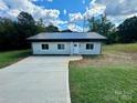 Newly built light gray house with dark gray metal roof and a long driveway at 901 Linney Ln, Shelby, NC 28152