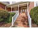 Brick front entry with wooden door and stairs at 2488 Birdie Ne Ln, Conover, NC 28613