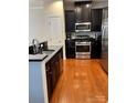 Kitchen with dark cabinets, granite counters, and island at 7308 Gallery Pointe Ln, Charlotte, NC 28269