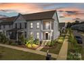 Gray two-story townhome with front porch and landscaping at sunset at 10193 Meeting House Nw Dr, Huntersville, NC 28078