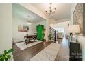 Bright entryway with wood floors, green accent cabinet, and view to living room at 540 Kenway Loop, Mooresville, NC 28117