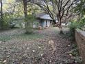 Small cottage with a front porch and overgrown yard at 213 Belt Dr, Lowell, NC 28056