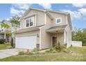 Tan two-story house with a two-car garage and well-maintained landscaping at 12009 Downy Birch Rd, Charlotte, NC 28227