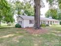 Ranch home with white brick exterior, metal roof, and large tree in front yard at 8909 Highway 218 Hwy, Marshville, NC 28103