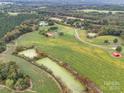 Aerial view highlighting home, pond, and agricultural land at 8510 Olive Branch Rd, Marshville, NC 28103