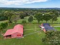 Aerial view showing a house, barn, and lush green landscape at 8510 Olive Branch Rd, Marshville, NC 28103